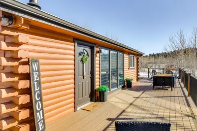 a cabin with a deck with a door and a table at Mtn-View Haven with Hot Tub 9 Mi to Dtwn Bailey in Bailey