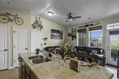 a kitchen with a sink and a living room at Aspen Meadows F-304, 0014 in Granby