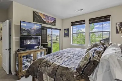 a bedroom with a bed and a tv and windows at Aspen Meadows F-304, 0014 in Granby
