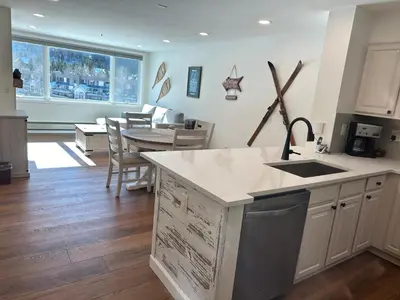 a kitchen with a sink and a table with chairs at Beautiful Renovated 1BR Lakeside Condo condo in Keystone