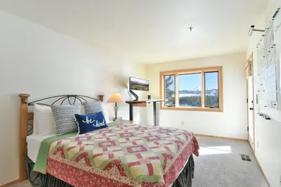 a bedroom with a bed and a window at Lake Forest Mountainview Condo: Great Location, Amazing Views in Frisco