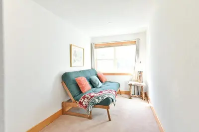 a living room with a green couch and a window at La Riva Del Lago Condo: Downtown, Close to Everything in Dillon