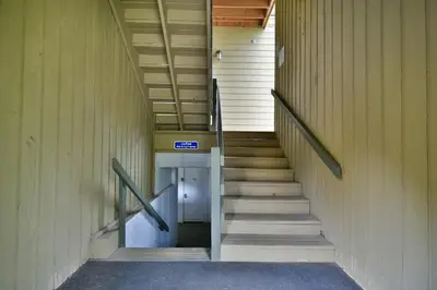 a staircase in a building with a blue sign on it at Woodbridge Inn Getaway: Pet Friendly, Mountain Views in Frisco