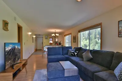 a living room with a blue couch and a tv at Woodbridge Inn Getaway: Pet Friendly, Mountain Views in Frisco