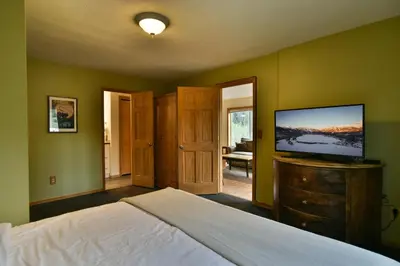 a bedroom with a bed and a flat screen tv at Woodbridge Inn Getaway: Pet Friendly, Mountain Views in Frisco