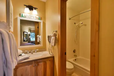 a bathroom with a sink and a toilet and a mirror at Flying Dutchman Mountainside Condo: Pool/Hot Tub in Keystone