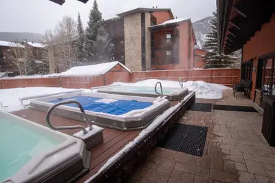 a hot tub on a deck with snow on it at Mountainside Royalview Condo: Pool/Hot Tubs, Great Location in Frisco