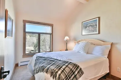 a bedroom with a large bed and a window at Prospect Point Retreat: Lakeside Townhome, Mountain Views in Frisco