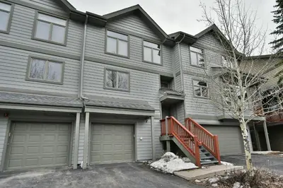 a gray house with a garage at Prospect Point Retreat: Lakeside Townhome, Mountain Views in Frisco