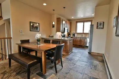 a large kitchen with a wooden table and chairs at Prospect Point Retreat: Lakeside Townhome, Mountain Views in Frisco