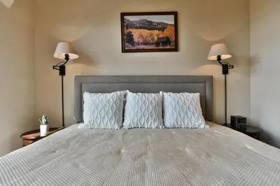 a bedroom with a large bed with two lamps at Prospect Point Retreat: Lakeside Townhome, Mountain Views in Frisco