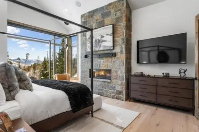 a bedroom with a stone wall and a fireplace at Brand New Eagles Nest Property in Silverthorne