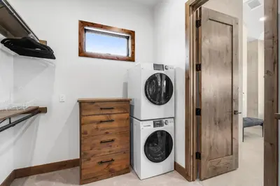 a laundry room with a refrigerator and a washer and dryer at Brand New Eagles Nest Property in Silverthorne