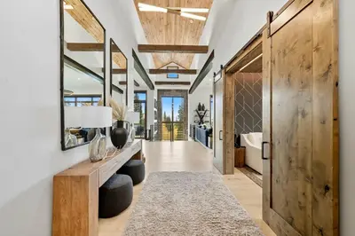 a hallway with a wooden door and a mirror at Brand New Eagles Nest Property in Silverthorne