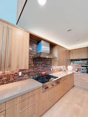 a kitchen with wooden cabinets and a stove top oven at Luxe 4 bed 5 bath with Parking Walk to Capitol, Convention Center, museums and shops in Denver