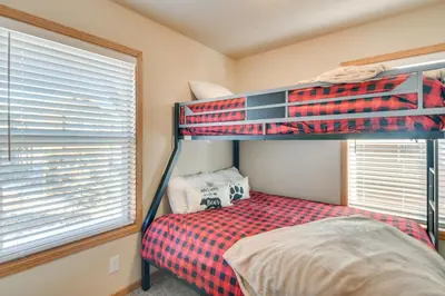 a bedroom with two bunk beds and a window at 4 Mi to Granby Ranch Cabin with Hot Tub Access! in Granby