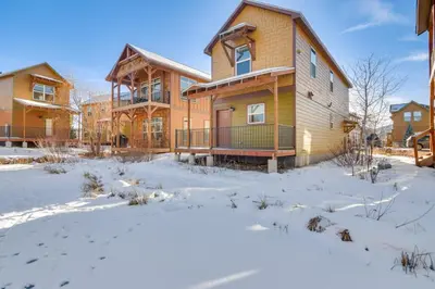 a house with snow on the ground in front of it at 4 Mi to Granby Ranch Cabin with Hot Tub Access! in Granby