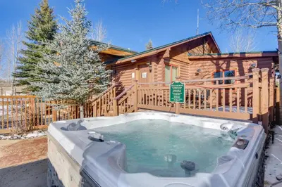 a hot tub in front of a log cabin at 4 Mi to Granby Ranch Cabin with Hot Tub Access! in Granby