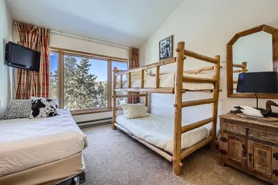 a bedroom with two bunk beds and a tv at 2017 Lodgepole condo in Keystone