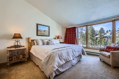 a bedroom with a bed and a window and a chair at 2017 Lodgepole condo in Keystone