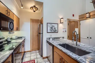 a kitchen with a sink and a refrigerator at 2017 Lodgepole condo in Keystone