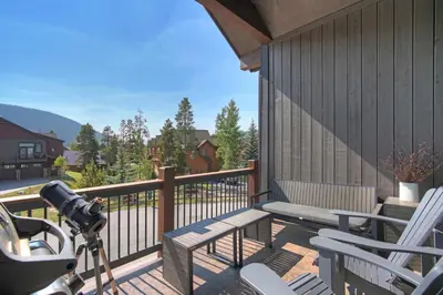 a camera on a deck with chairs and a bench at Luxury Home - Sleeps 10 - Fireplace & Mountain View condo in Keystone