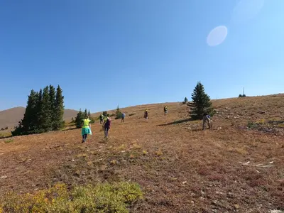 a group of people walking up a hill flying a kite at Luxury Home - Sleeps 10 - Fireplace & Mountain View condo in Keystone