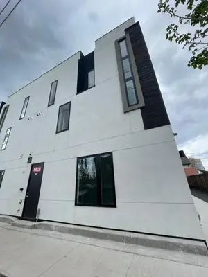 a white building with black windows on a street at RiNo Self-Care Studio in Denver