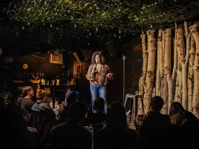 a woman standing on a stage in front of a crowd at RiNo Self-Care Studio in Denver
