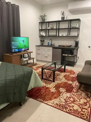 a living room with a tv and a couch and a table at RiNo Self-Care Studio in Denver
