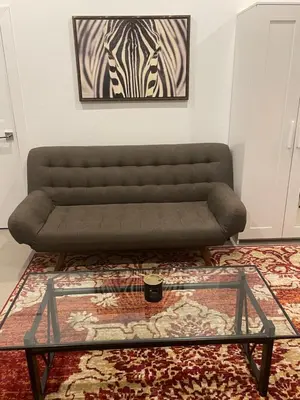 a couch in a living room with a glass coffee table at RiNo Self-Care Studio in Denver