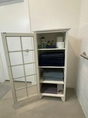 a white shelf in a bathroom with a mirror at RiNo Self-Care Studio in Denver