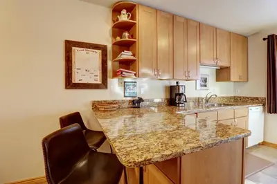 a kitchen with a granite counter top and wooden cabinets at 727B Meadow Creek townhouse in Frisco