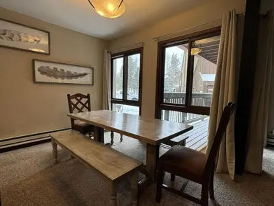 a dining room with a wooden table and a window at Beautiful Renovated 3BR in Keystone condo in Keystone