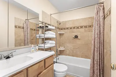 a bathroom with a sink and a toilet and a tub at Cozy Central Aurora Home in Aurora