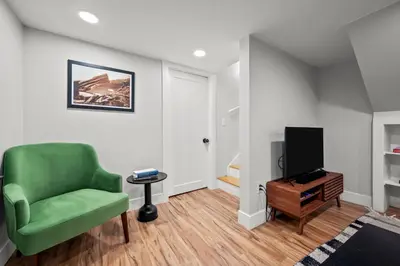 a living room with a green chair and a tv at Downtown Stay off Broadway Nightlife Nearby Parking in Denver