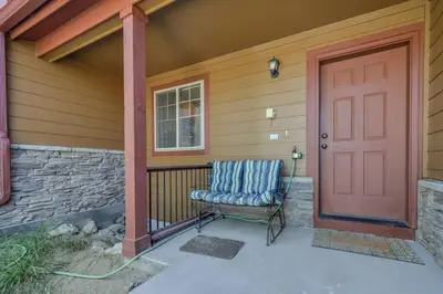 a front door of a house with a chair next to it at Majestic Views - Steps to the Trails! in Fraser
