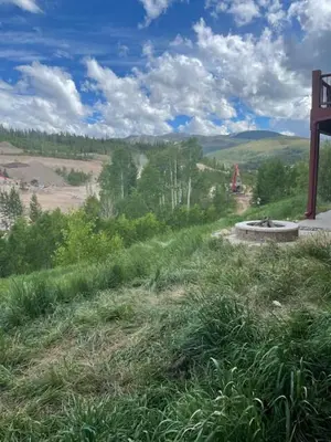 a view of a grassy hill with a field in the background at Majestic Views - Steps to the Trails! in Fraser