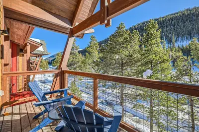 a balcony with chairs and a view of the mountains at 1890 The Seasons townhouse in Dillon