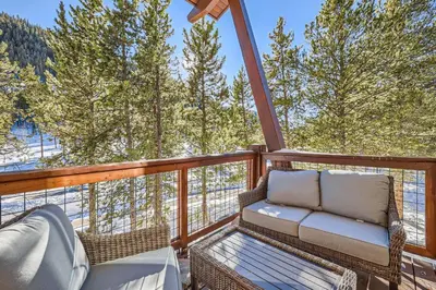 a balcony with a couch and chairs and trees at 1890 The Seasons townhouse in Dillon