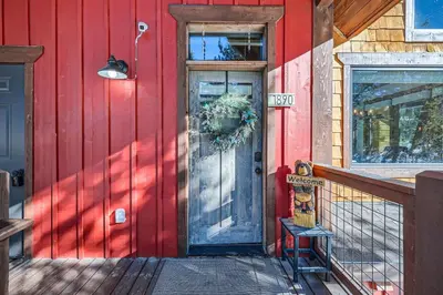 a red house with a door and a sign on it at 1890 The Seasons townhouse in Dillon