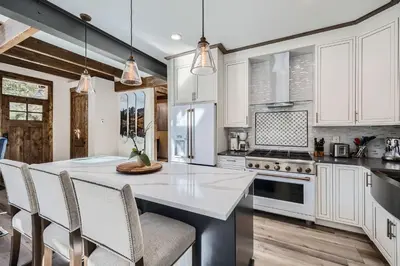 a kitchen with white cabinets and a table with chairs at 1890 The Seasons townhouse in Dillon