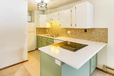 a kitchen with white cabinets and a counter top at Walk to Winter Park Resort Condo with Hot Tub! in Winter Park