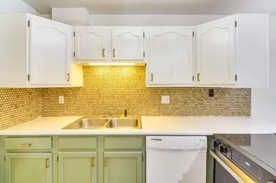 a kitchen with white cabinets and a sink at Walk to Winter Park Resort Condo with Hot Tub! in Winter Park