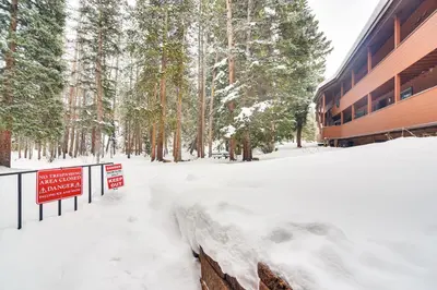 a snow covered building with a sign in the snow at Walk to Winter Park Resort Condo with Hot Tub! in Winter Park
