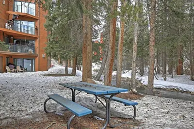 a picnic table and a bench in front of a building at Walk to Winter Park Resort Condo with Hot Tub! in Winter Park