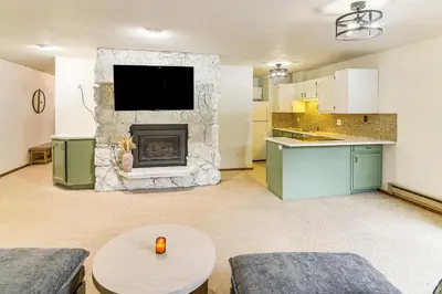 a living room with a fireplace and a tv at Walk to Winter Park Resort Condo with Hot Tub! in Winter Park