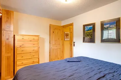 a bedroom with a bed and a wooden door at Pool and 3 Hot Tubs Winter Park Condo on Bus Line in Winter Park