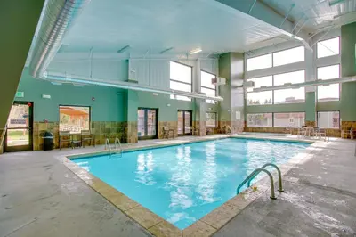 a large indoor swimming pool with blue water at Pool and 3 Hot Tubs Winter Park Condo on Bus Line in Winter Park