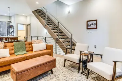 a living room with a couch and chairs and a staircase at Hot Tub and Views Getaway 8 Mi to Keystone Resort! in Silverthorne